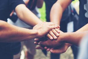 Picture of a group of employees putting their hands into a circle.