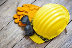 Picture of a hard hat, safety gloves, and sunglasses.
