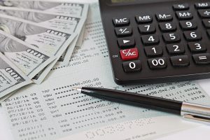 Picture of money. a pen, and a calculator.