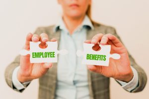 Woman holding two puzzle pieces that say employee and Benefits