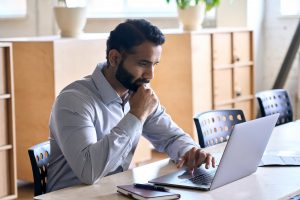 Executive studying laptop thoughtfully