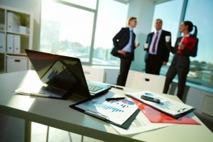 Three executives having a standing meeting in corner office